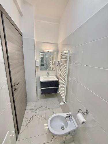 a white bathroom with a sink and a toilet at Luna Guest House in Pisa