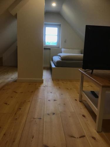 a room with a bed and a wooden floor at Naturblick in Hennstedt
