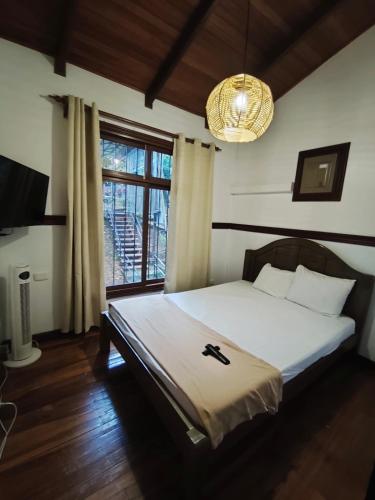a bedroom with a bed and a large window at Ávita Lodge in Quesada