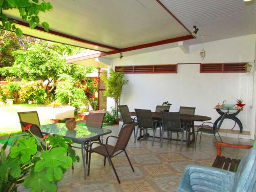un patio con mesa, sillas y mesa en Inaiti Lodge, en Papeete