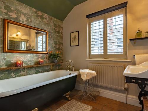 a bathroom with a tub and a sink and a mirror at 5 Bed in Dunster 63301 in Dunster