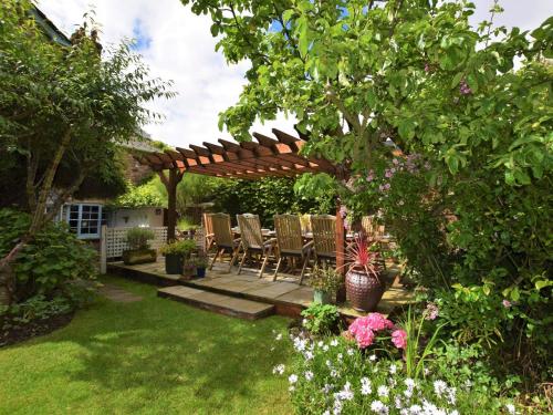 a patio with chairs under a wooden pergola at 5 Bed in Dunster 63301 in Dunster