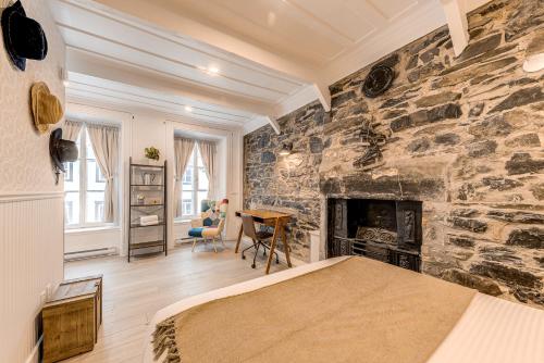 a bedroom with a stone wall with a fireplace at North House - Gorgeous 3 Bedroom 2-floor Old Quebec Townhouse in Quebec City