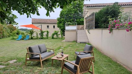two chairs and a table in a yard at Gîte du Soleil Levant - Drôme des collines in Bren