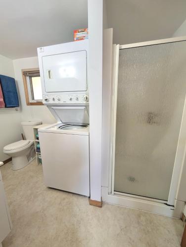 a small kitchen with a refrigerator and a toilet at 2 Bed Rustic Retreat at Bois Joli Beach in Grand Barachois