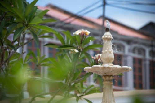 a white statue in front of some plants at Jawi Peranakan Mansion in George Town