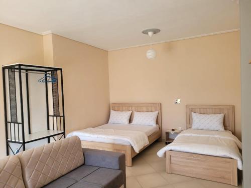 a room with two beds and a couch in it at House Rooms Korce in Korçë