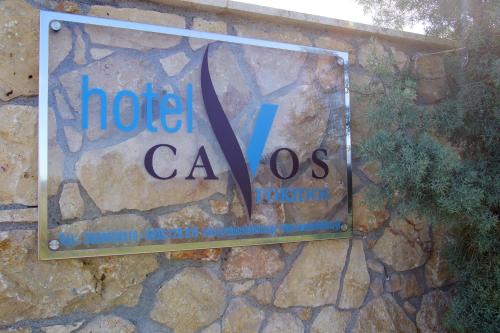 a sign for a hotel caross on a stone wall at Cavos Fokidos in Chiliadou