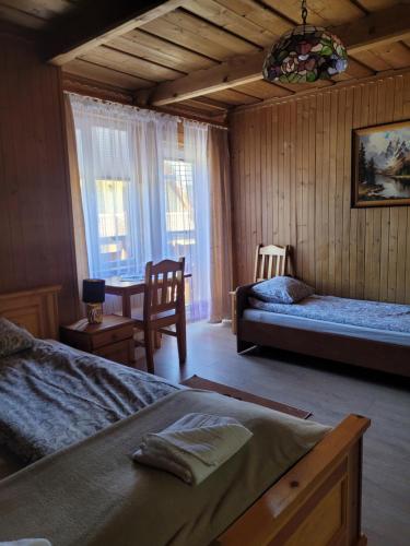 扎科帕内Kowali Wierch的一间卧室，有两张床、一张桌子和一张书桌