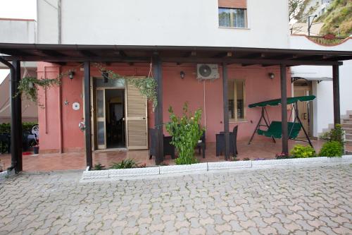 a pink house with a porch with a swing at BnB La Casa di Monica in Silvi Paese
