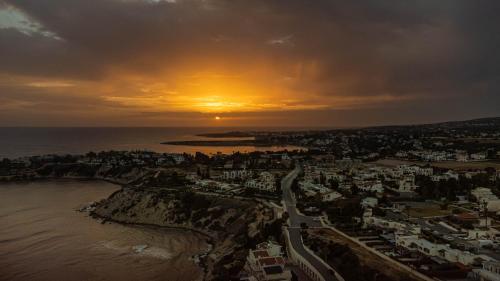 an aerial view of a city with the sunset at Villa Talya in Peyia