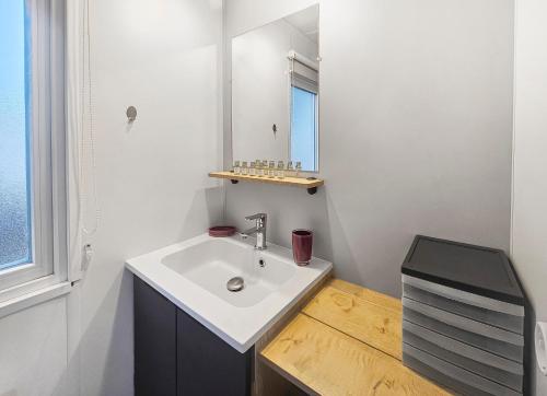 une salle de bain avec un lavabo et un miroir dans l'établissement un air de vacances, à Litteau