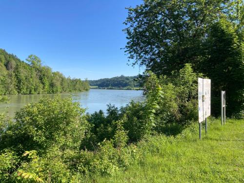 a sign in the grass next to a river at Ferienwohnung Schreiner Innblick in Wernstein am Inn