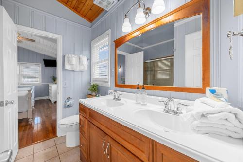 a bathroom with a sink and a mirror and a toilet at Channel Vibes in Myrtle Beach