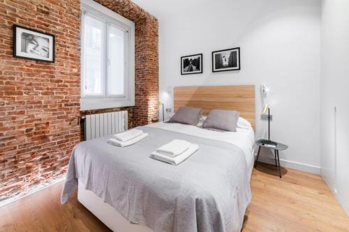 sypialnia z dużym łóżkiem w ścianie z cegły w obiekcie 2 bedrooms 1 bathroom furnished - Centro - equipped & stylish - Minty Stay w Madrycie