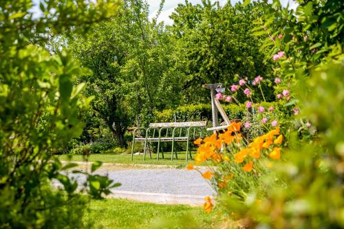 a garden with a bench and flowers in the grass at Gîte chezmadlou in Colondannes