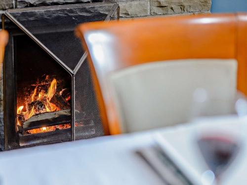 a fireplace sitting next to a table with a chair at 5 Bed in Bingley 91977 in Bingley