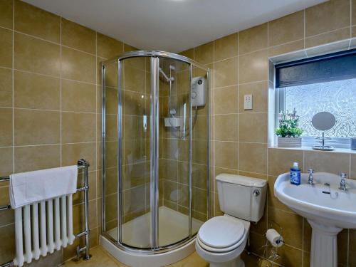 a bathroom with a shower and a toilet and a sink at 5 Bed in Bingley 91977 in Bingley