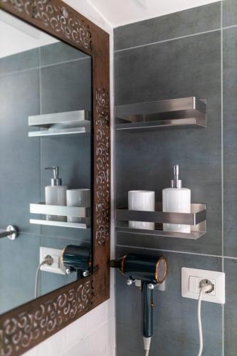 a bathroom with a mirror and a sink at Tosti 79 in Formia