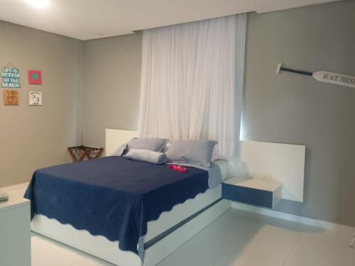 ein Schlafzimmer mit einem blauen Bett und einem Fenster in der Unterkunft Casa Toquinho Ipojuca-PE in Ipojuca