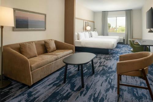 a hotel room with a couch and a bed at Fairfield by Marriott Inn & Suites Scottsdale Old Town in Scottsdale