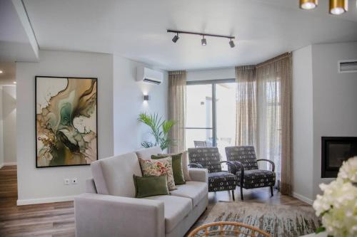 a living room with a couch and a table and chairs at Casa do Senhor do Colégio in Ponta Delgada