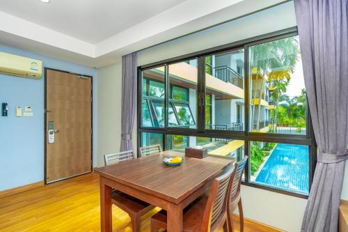 a dining room with a table and a large window at Anchan Boutique Hotel in Chalong 