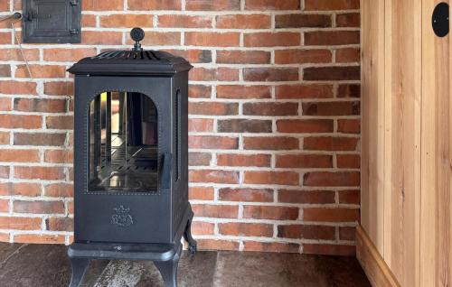 a black stove in front of a brick wall at Gorgeous Home In Ydre With Sauna in Hult