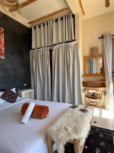 a bedroom with a large white bed with a window at SurfAppart Morocco in Tamraght Ouzdar