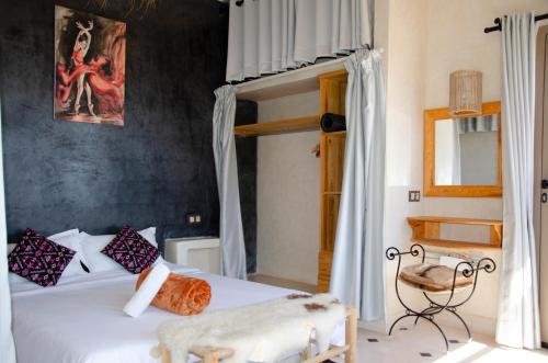 a bedroom with a white bed with a poster on the wall at SurfAppart Morocco in Tamraght Ouzdar