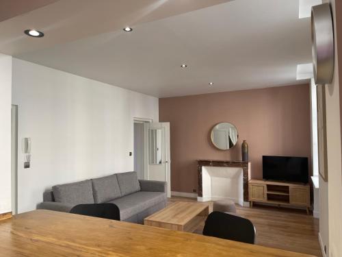 un salon avec un canapé et une cheminée dans l'établissement Appartement Centre ville Historique, à Bayeux