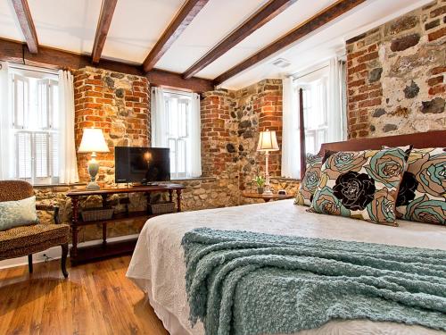 サバンナにあるHabersham Houseのベッドとレンガの壁がある寝室