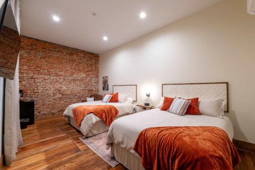 una camera da letto con due letti e un muro di mattoni di Cozy Corner - Room 5 a Versailles
