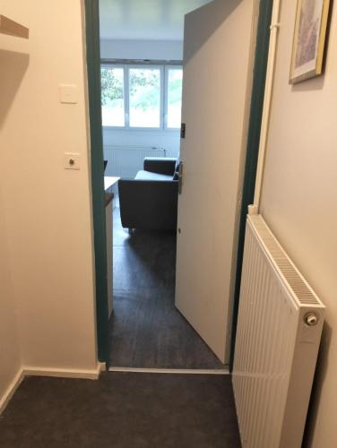 un couloir avec une porte menant à un salon dans l'établissement Elysée 2, à La Celle-Saint-Cloud