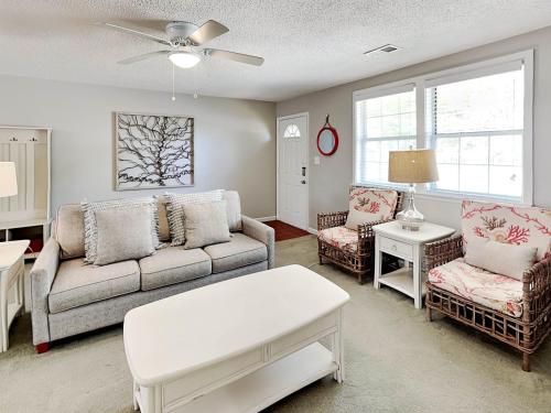 a living room with a couch and two chairs at Latitude Adjustment A in Tybee Island