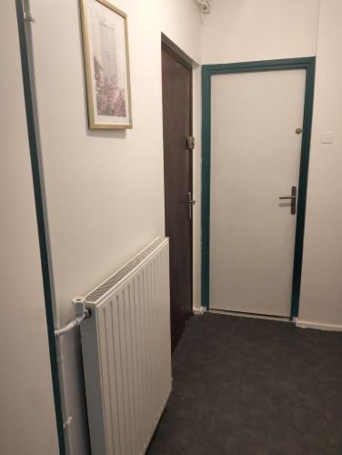 un couloir avec une porte blanche et une photo sur le mur dans l'établissement Elysée 2, à La Celle-Saint-Cloud