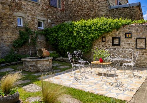 a patio with chairs and a table and a fountain at Gîte chezmadlou in Colondannes