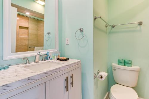 a bathroom with a toilet and a sink and a mirror at Walk to Beach Coligny Gem with Community Perks! in Hilton Head Island