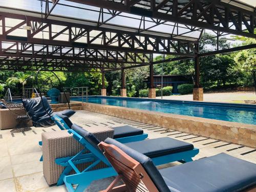 a pool with lounge chairs and a swimming pool at Ávita Lodge in Quesada