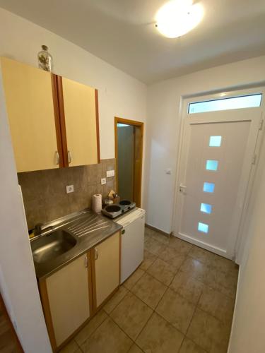 メリネにあるApartman Vidikの小さなキッチン(シンク、ドア付)