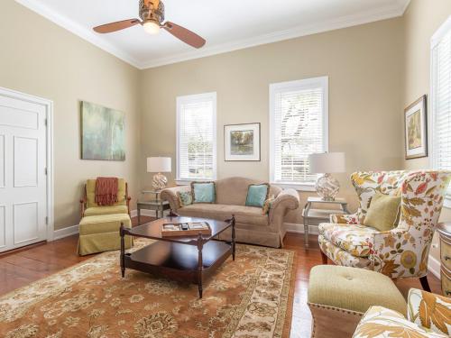 a living room with a couch and chairs and a ceiling fan at Habersham 1 in Savannah