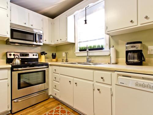 a kitchen with white cabinets and a sink at Habersham 1 in Savannah
