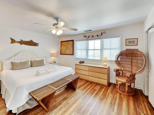 a bedroom with a bed and a chair and a window at Weston Beach Place in Tybee Island