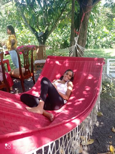 a woman laying on a hammock in a tree at Paraiso Hortensia Ecolodge in Santiago de los Caballeros