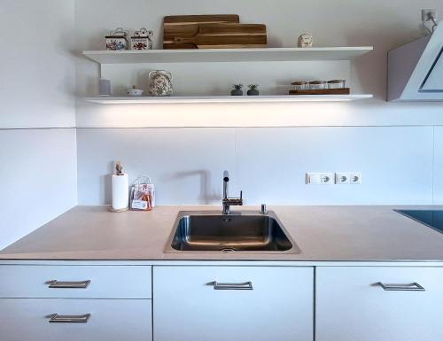 a kitchen with a sink and white cabinets at Landhaus Jarnitz in Ralswiek
