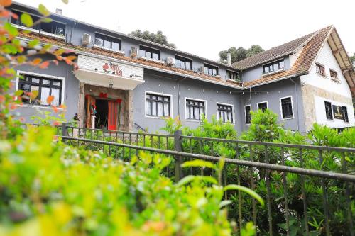 a large building with a red door in a yard at Pousada Vista do Lago: Lazer e família em Gramado! in Gramado
