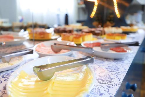a buffet with plates of food on a table at Pousada Vista do Lago: Lazer e família em Gramado! in Gramado