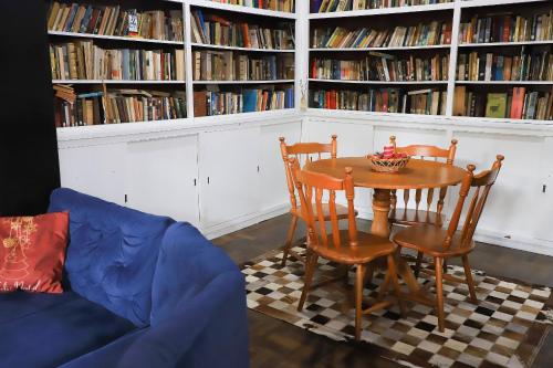 a living room with a table and chairs and bookshelves at Pousada Vista do Lago: Lazer e família em Gramado! in Gramado