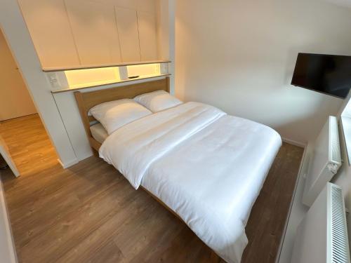 a small bedroom with a bed with white sheets at Landhaus Jarnitz in Ralswiek