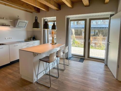 a kitchen with a counter and stools in a room at Landhaus Jarnitz in Ralswiek